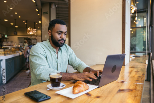 Focused Man working with laptop in a coffee shop