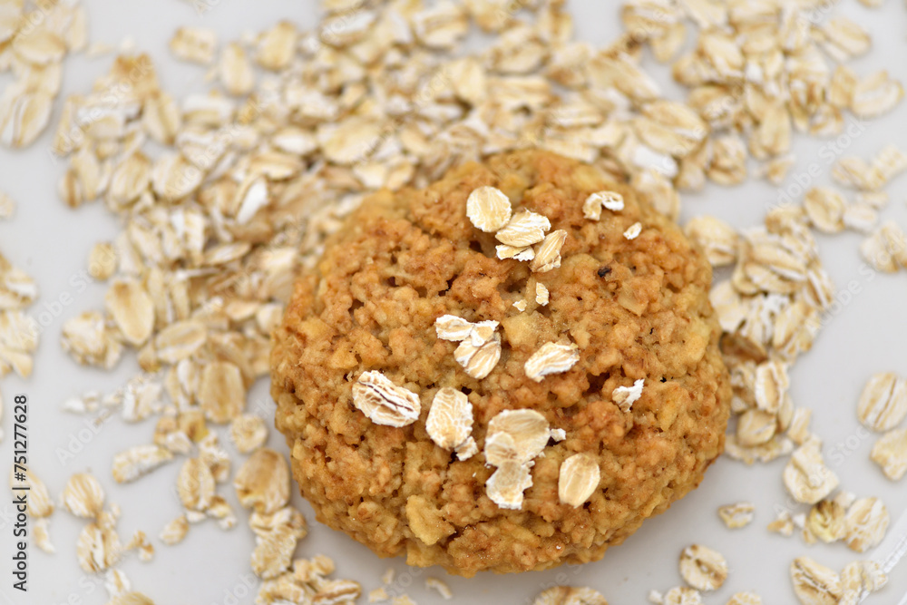 Oatmeal cookies with oat flakes on a white plate. Healthy food for breakfast or a snack. Close up. Soft focus