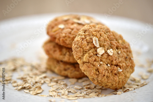 Oat cookies with oat flakes on a white plate. Healthy food for breakfast or a snack. Close up. Soft focus