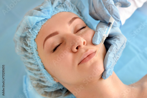Cosmetologist does injections on the face of a beautiful woman in a beauty salon. Cosmetology concept.