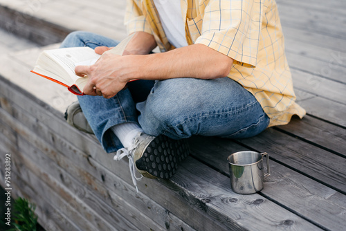 A man reads a book outdoors