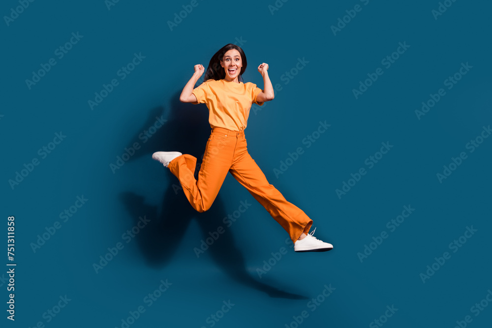 Full length body photo of overjoyed winner energetic girl sports competition raised fists up isolated over dark blue color background