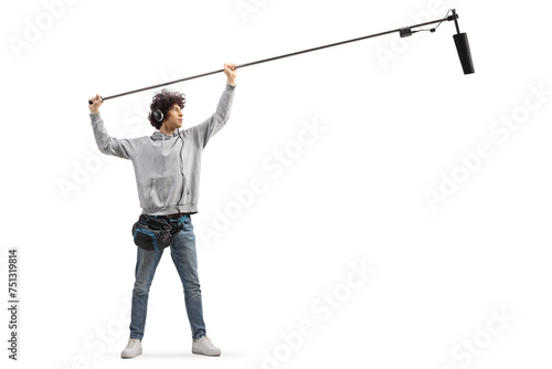 Full length shot of audio operator holding a microphone on set photo