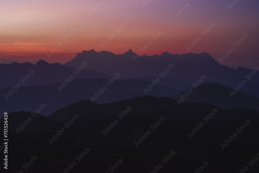 nature traveling with orange sky and layer of mountain with sunrise background