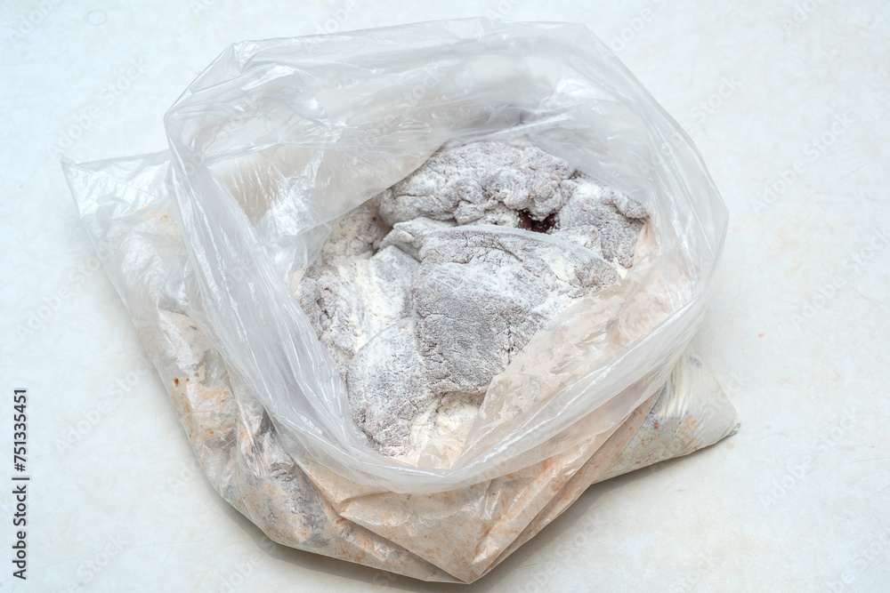 Pieces of beef liver, dipped in flour, in a cellophane bag. Pieces of beef liver, dipped in flour, in a cellophane bag.