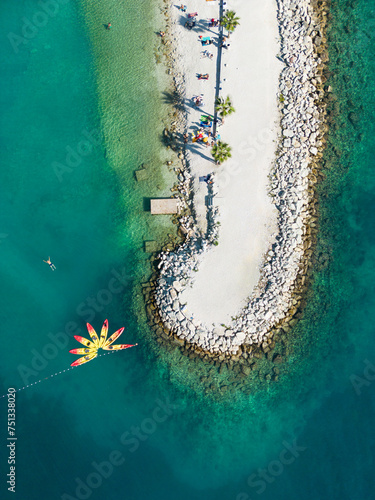 Fototapeta Naklejka Na Ścianę i Meble -  Aerial drone shot of Kasjuni beach near Split with brightly coloured kayaks and a swimmer