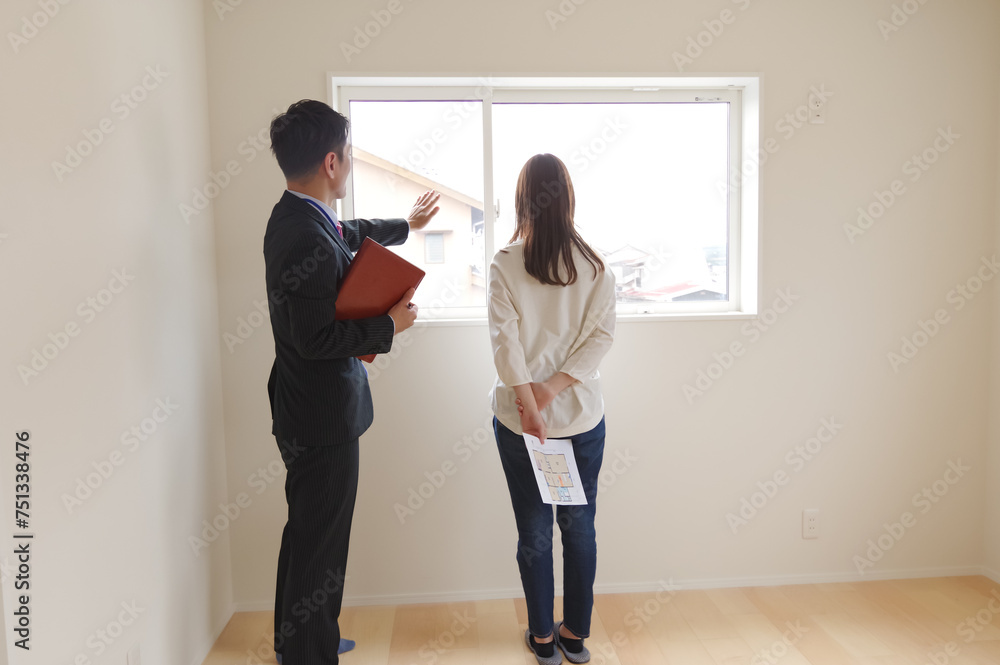 Fototapeta premium 不動産の案内をしている男性と女性