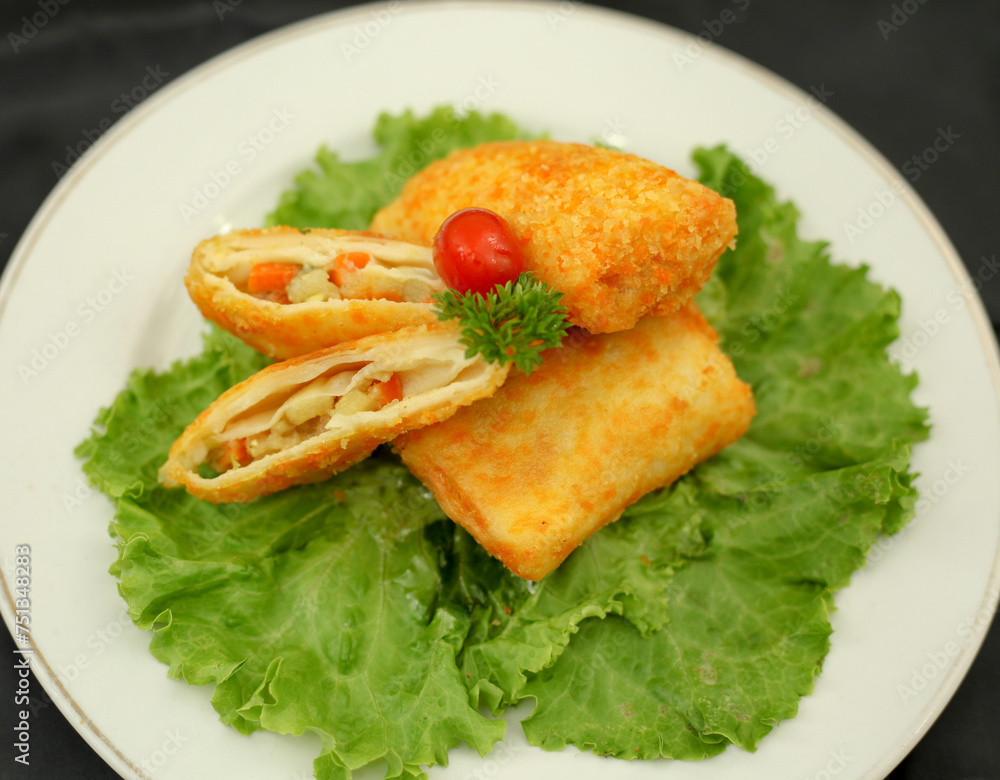 Risol filled with ragout. Salted fried snacks in the form of envelope or triangles. The filling is consisting of vegetables, shrimps, eggs and curry. The outer shell is coated with breadcrums. Risol filled with ragout. Salted fried snacks in the form of envelope or triangles. The filling is consisting of vegetables, shrimps, eggs and curry. The outer shell is coated with breadcrums.