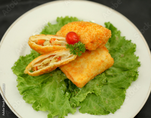 Risol filled with ragout. Salted fried snacks in the form of envelope or triangles. The filling is consisting of vegetables, shrimps, eggs and curry. The outer shell is coated with breadcrums.