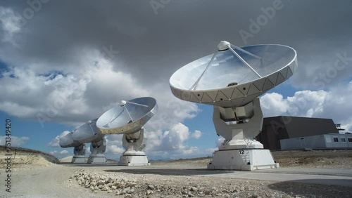 Wide static shot of the Plateau de Bure radio telescope array in France. Ground-level wide shot of large millimeter-wave radio astronomy antennas. photo