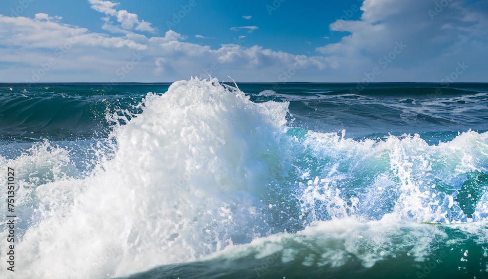 Powerful foamy sea waves rolling and splashing over water surface against cloudy blue sky Powerful foamy sea waves rolling and splashing over water surface against cloudy blue sky