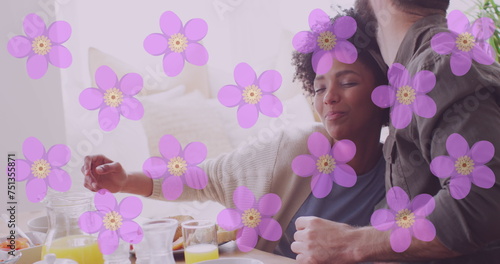 Image of flowers over happy diverse couple eating together