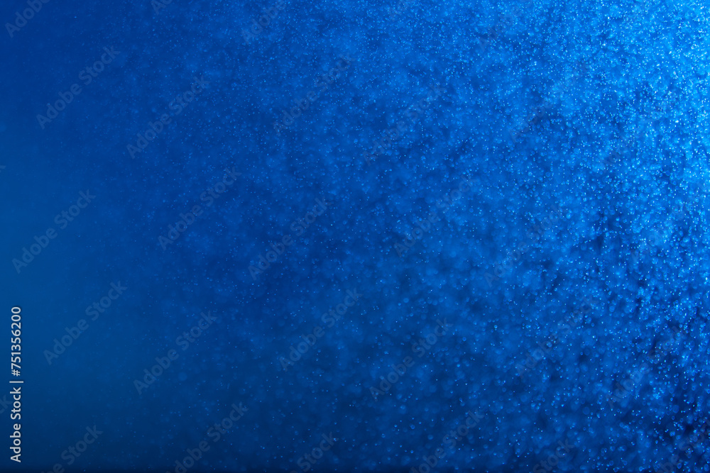 abstract blue sparkling background with a ray of light and many small splashes abstract blue sparkling background with a ray of light and many small splashes