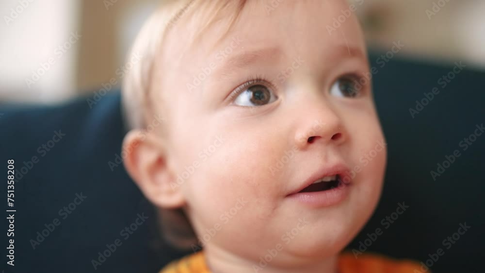 baby portrait close-up looking at the camera. happy family kid dream concept. baby blond indoors at home looking at the camera. child son smiling sitting lifestyle on the sofa close-up baby portrait close-up looking at the camera. happy family kid dream concept. baby blond indoors at home looking at the camera. child son smiling sitting lifestyle on the sofa close-up
