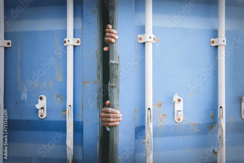 Foto Human trafficking : Hand of a stateless black man hiding container trying to escape the country hire workers working illegally in third countries and try to hide in shipping containers