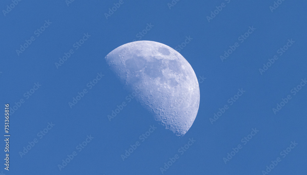 The waning moon in the evening in winter with blue sky The waning moon in the evening in winter with blue sky