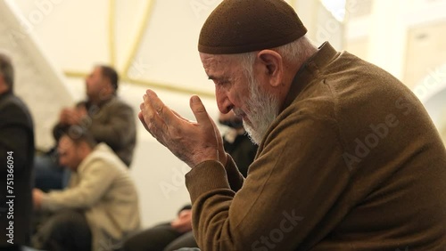  Old Muslim man with a prayer cap praying to Allah at Mosque in Ramadan month photo