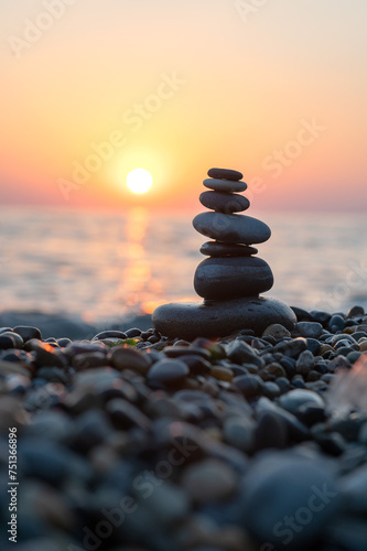 Balancing stones on the seashore at sunset