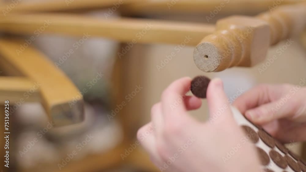 Vidéo Stock A woman glues pads to the legs of a chair to prevent them