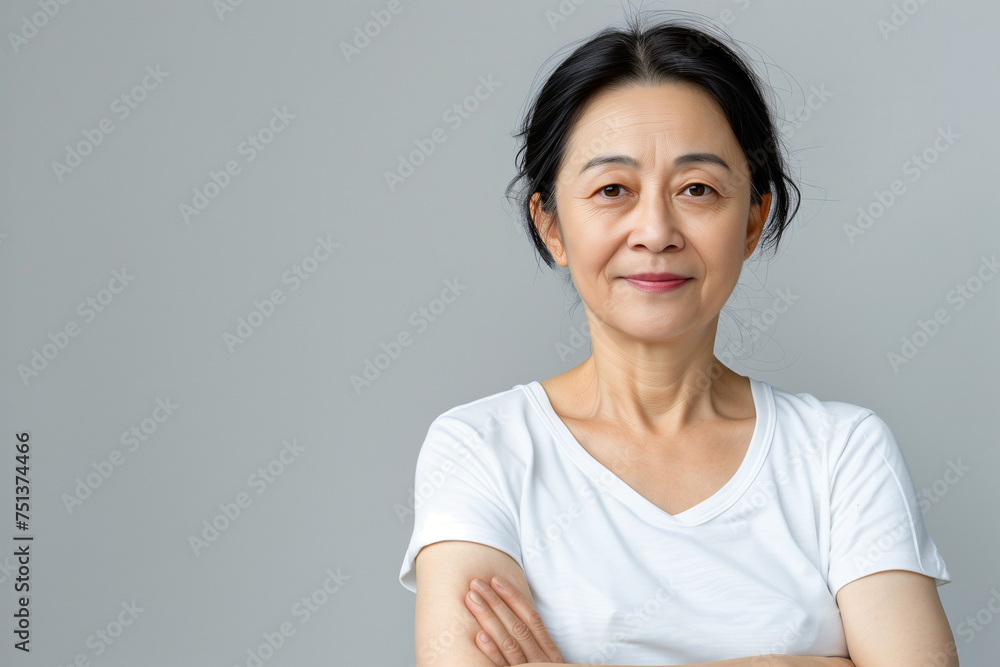 Elegant Mature Asian Woman in White Shirt with Confident Smile and Arms Crossed, Embodying Timeless Grace Elegant Mature Asian Woman in White Shirt with Confident Smile and Arms Crossed, Embodying Timeless Grace