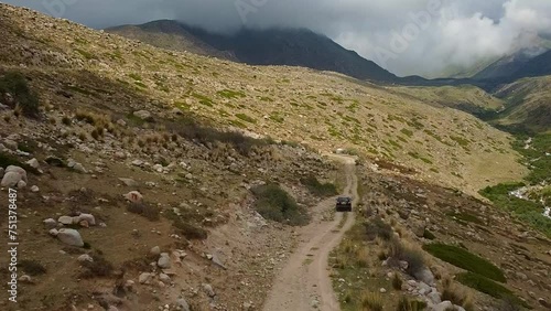 Drone: flies behind a car through a gorge in the mountains of Kyrgyzstan
