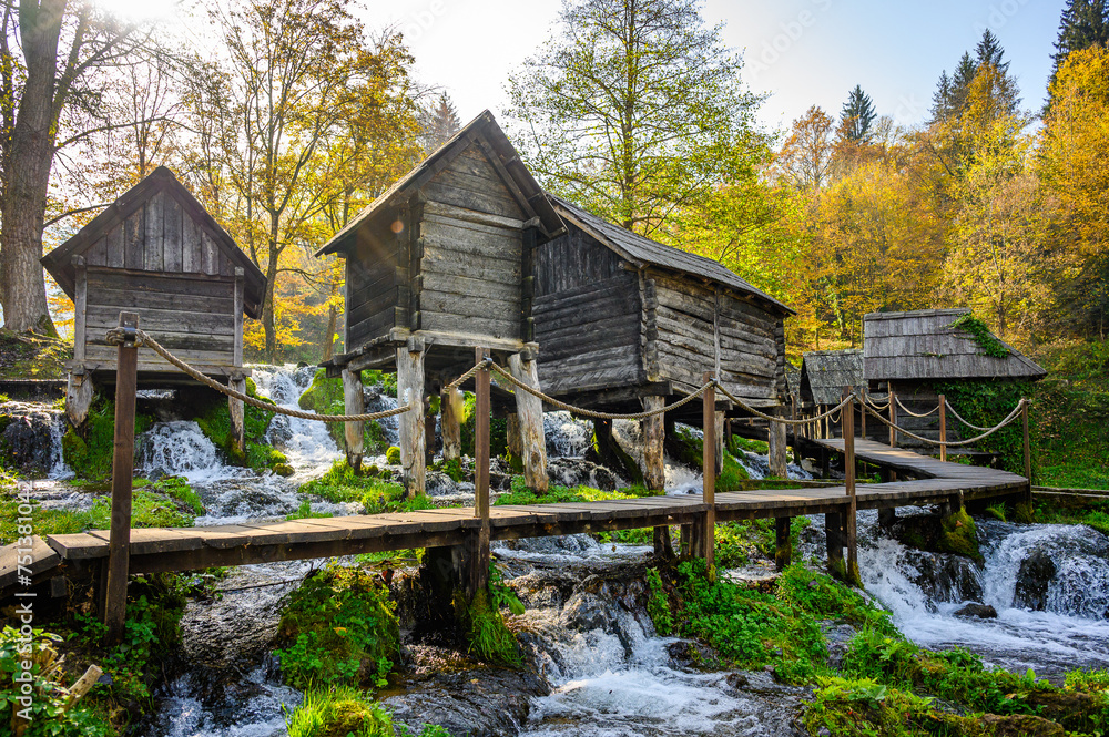 Old small wooden water mills called Mlincici built on Pliva lake near Jajce, Bosnia and Herzegovina. - obrazy, fototapety, plakaty 