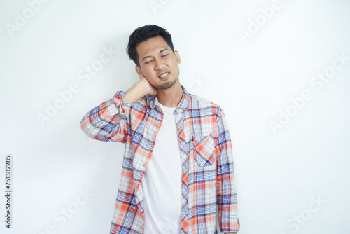 Adult Asian man touching back of his neck with pain expression