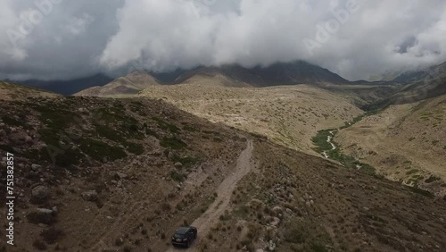 Drone: flies behind a car through a gorge in the mountains of Kyrgyzstan