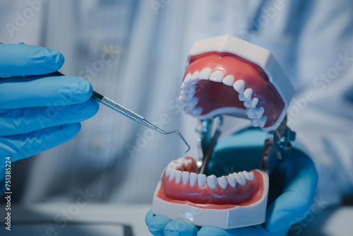 A dentist is using specialized dental equipment to inspect dentures to study the anatomy of the teeth before using the knowledge to treat patients, Dentures are being studied by oral specialists. photo