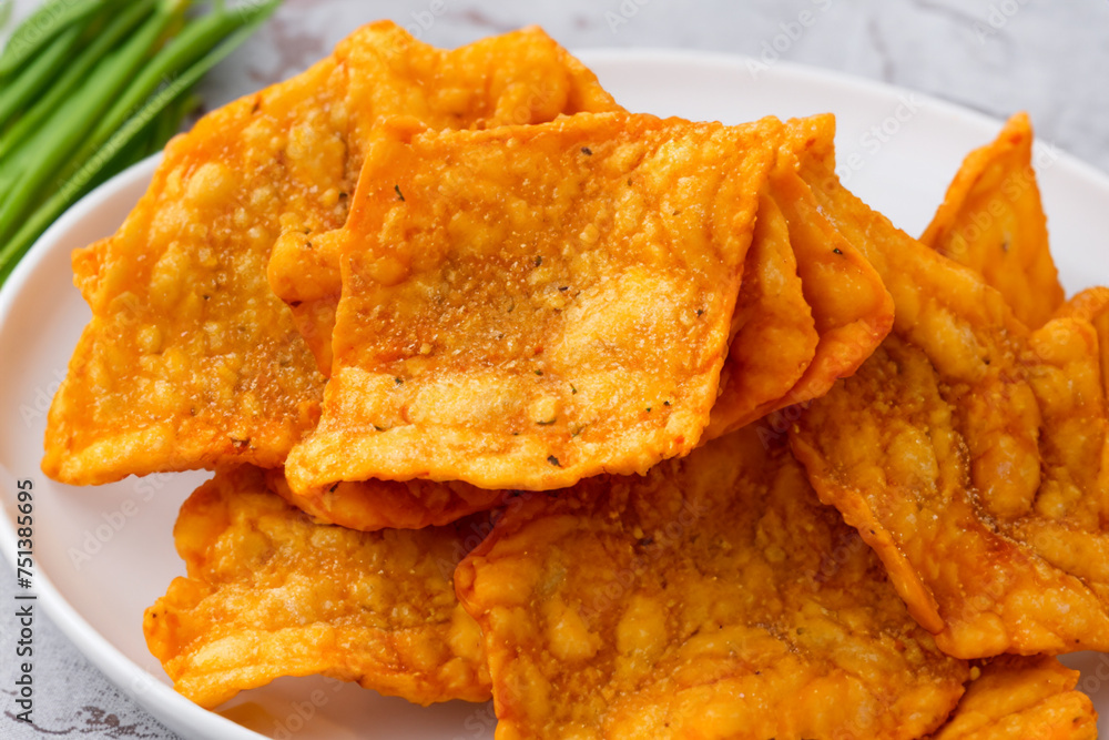 meat chips. on a marble table there is a plate with breaded meat chips, a bunch of green onions lies nearby, close-up, snack concept meat chips. on a marble table there is a plate with breaded meat chips, a bunch of green onions lies nearby, close-up, snack concept