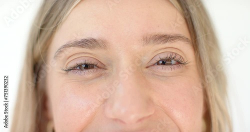 Close-up of a young Caucasian woman with a subtle smile and light brown eyes