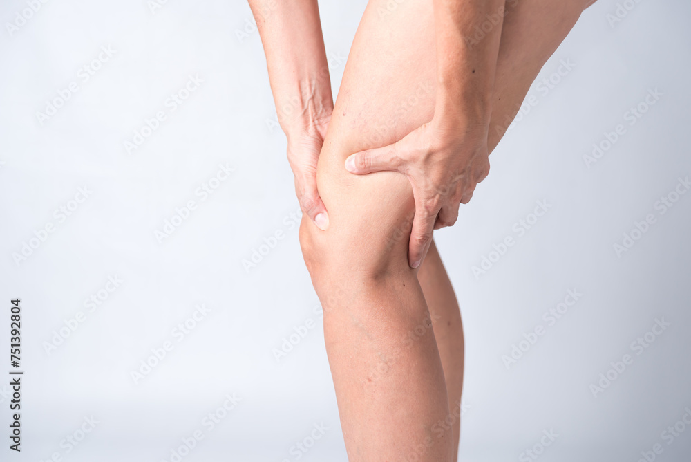 A person with a knee injury is holding their knee. Concept of pain and discomfort A person with a knee injury is holding their knee. Concept of pain and discomfort