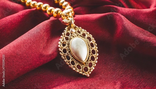 golden necklace with pendant on red silk background