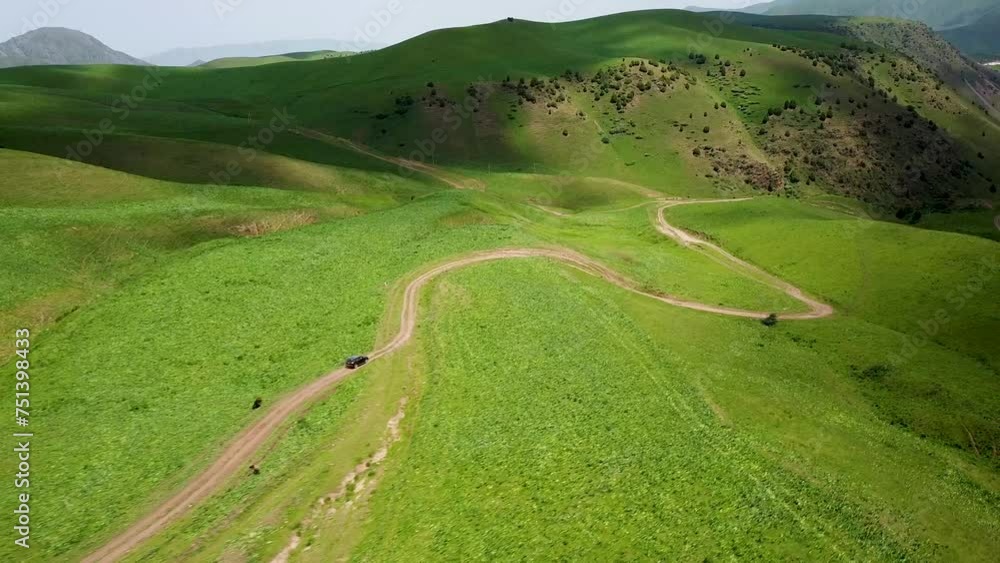Drone: flies behind a car along the valley of the mountains of Kyrgyzstan Drone: flies behind a car along the valley of the mountains of Kyrgyzstan