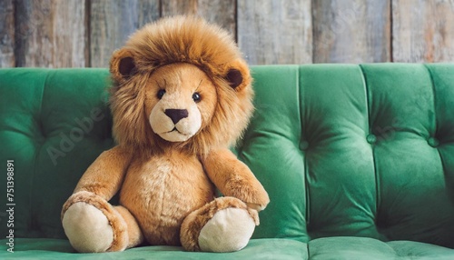 teddy bear lion sitting on a green sofa on a background
