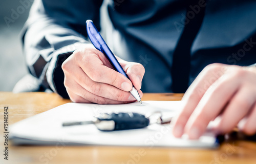 Car lease loan document. Auto finance or insurance paperwork. Sell, rent or buy used vehicle. Dealership company or rental agency contract policy. Credit application form. Man signing agreement. photo