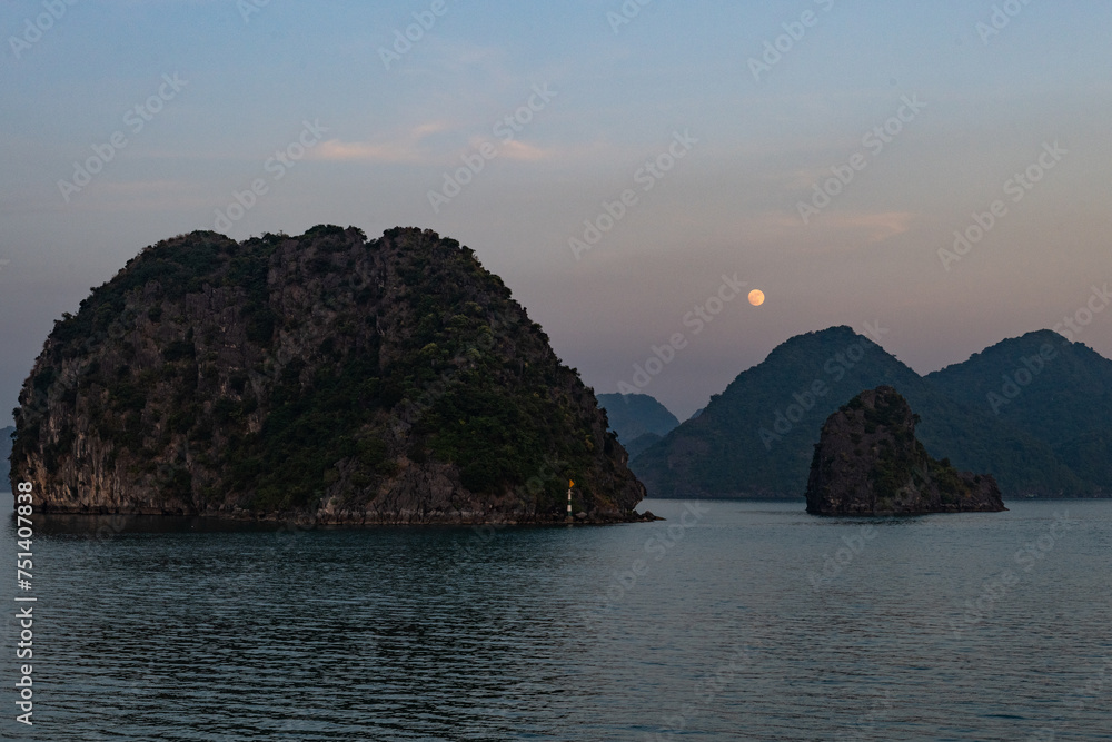 Full moon rise over limestone islands of Ha Long Bay in Vietnam.