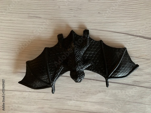 Plastic flitter-mouse on grey woodimitation surface.