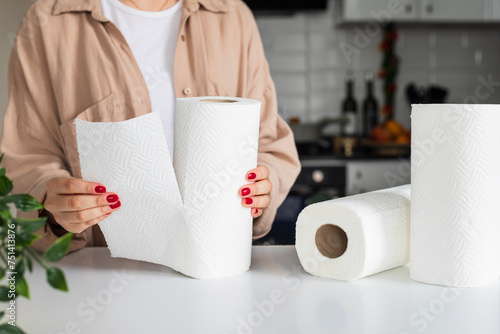 Woman tearing paper towels in kitchen, closeup