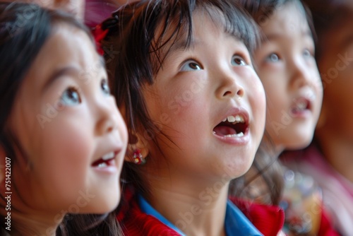 A close-up of asian girls children's faces, filled with excitement and wonder, watching performance on Children's Day