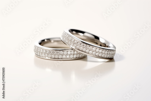 Elegant wedding rings with diamond pavé on a reflective surface