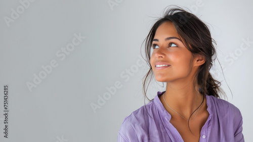 Indian woman wearing purple shirt smile looking up isolated on gray © pariketan
