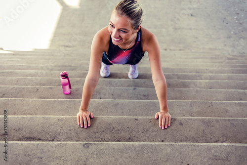 Young woman doing push-ups on stairs. Urban fitness woman workout doing torso elevated push ups on urban stairs. Motivated strong female athlete training hard.