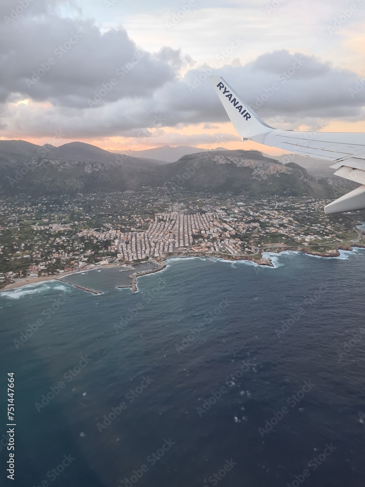 evocative image of the sea coast in Sicily seen from an airplane during a flight evocative image of the sea coast in Sicily seen from an airplane during a flight