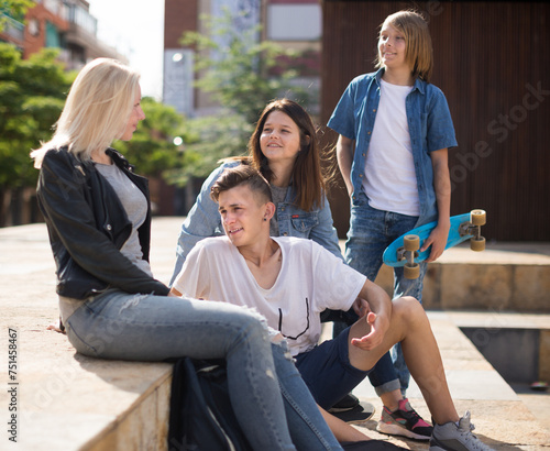 Teenagers socialize in the schoolyard on the street