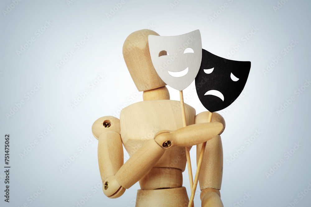 Wooden mannequin with two masks showing different emotions - Concept of psychology, mood change and bipolar disorder - obrazy, fototapety, plakaty 