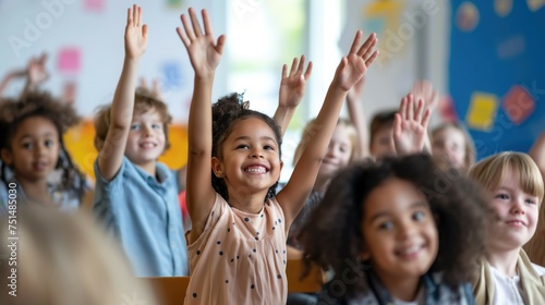 Primary school diverse cheerful smiling children sitting in light classroom with their hands up eager to answer the teacher's question