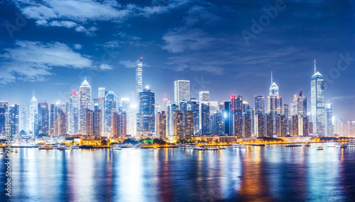 A stunning panoramic night view of the modern city skyline of Shanghai, China, with the Huangpu River in the foreground and the Oriental Pearl Tower and Jin Mao Tower in the background. photo