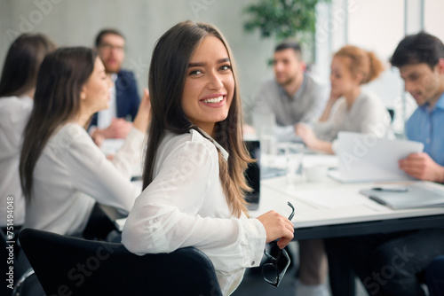 Positive secretary smiling to camera during meeting