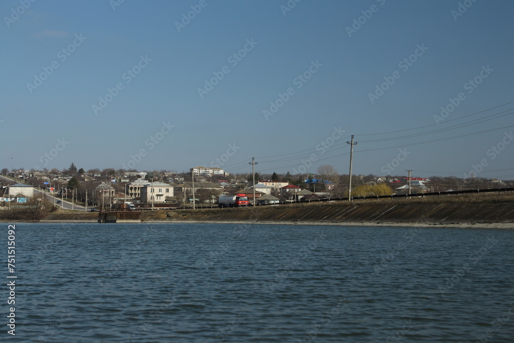 A body of water with houses and a rainbow in the sky